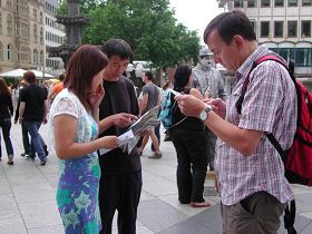 '路人仔细阅读传单，了解法轮功真相'