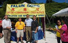 罗州财政部长及州长候选人卡普里奥（左三）和助理访法轮功展位并和学员合影