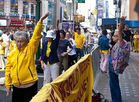 '家住布鲁伦的乌克兰裔舞蹈老师玛丽安娜˙布卢姆站在法轮功学员旁边,边看边学了近一个小时,她说感觉非常好,好象灵魂都自由了'