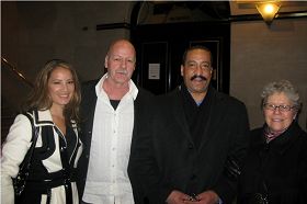 金融保险公司总裁麦克•麦纳米(左二)与妻子(左一)在布什耐尔剧场的康州神韵晚会上。