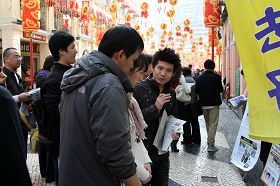 在澳门议事亭前地，义工们正忙着劝三<span