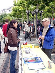 多米尼克（右）向民众讲法轮功真相