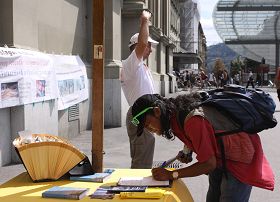 瑞士首都伯尔尼火车站广场上，路人签名声援法轮功反迫害