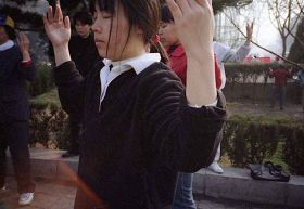 一九九九年四月初,几个炼功点的近千名法轮功学员在沈阳和平广场晨炼——炼功人群中的大学生,学员身前的红光,旋转的法轮。