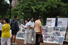 '游人观看法轮功真相展板'