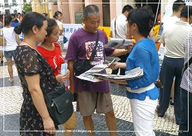 '图4：集会上，大法弟子向游客劝三<span