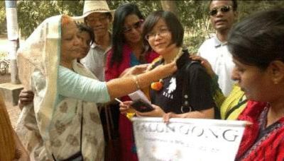 图3:感激小李教她炼法轮功,Tajkerak将花环给小李戴上