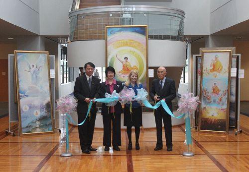 出席开幕式的嘉宾在为画展剪彩