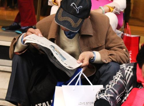 图3：文章刊登照片，一位Galeries Lafayette店前的中国大陆旅游者专心阅读《大<span style='max-width:0px!important;margin-left:-4px;color:#eee!important;'>.</span>纪<span style='max-width:0px!important;margin-left:-4px;color:#eee!important;'>.</span>元<span style='max-width:0px!important;margin-left:-4px;color:#eee!important;'>;</span>时报》。