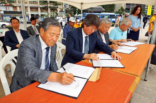 图9:图为韩国各界知名人士反迫害集会当场签署刑事举报江泽民联署书,要求中共当局立即法办迫害元凶。(左起朴熙道、崔佑源、徐京锡、金相宪)