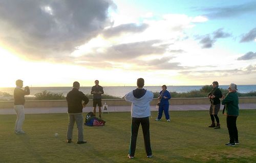 当地民众和法轮功学员们在海滨步道炼功。