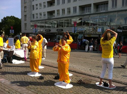 图2：法轮功学员在展位旁演示功法