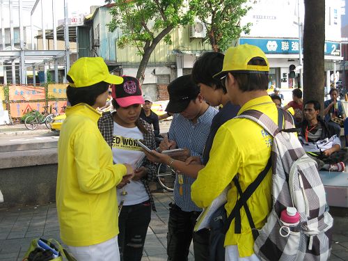 图10:越南籍的黎先生(中)想要学炼法轮功,仔细地记下明慧网的资讯。