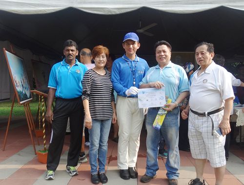 图7:太平市议会主席拿督阿都拉欣(右二)在“真善忍国际美展”前颁发参与证书于天国乐团,感谢他们的参与。