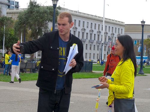 '图4:旧金山居民Richie King手拿着自己刚刚签过名的“制止活摘”征签表自拍留念。'