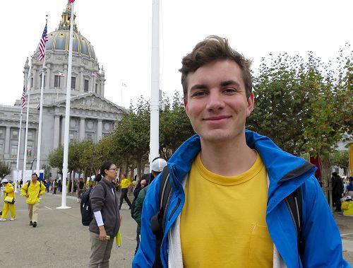 '图5:德国法轮功学员Tobias Piastowski很高兴游行沿途观看的民众非常乐意接受法轮功的真相资料。'