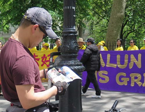 图12-15:法轮功学员举办的新闻发布会吸引过往路人驻足了解真相。