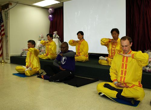 图4:马里兰州巴尔的摩举办的一个医疗健康午餐会上,会议组织者特别请了多位法轮功学员演示法轮功五套功法,内科医生斯蒂文·欧文斯当场学炼五套功法。