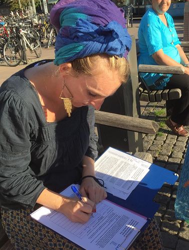 '图5-7:了解真相的人们签名支持法轮功学员制止迫害,制止活摘。'