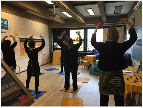 '图1～2：游客在芬兰“精神与认识”展会上学炼法轮功'