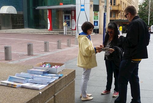 '图2~3:活动现场法轮功学员向过往民众讲真相'