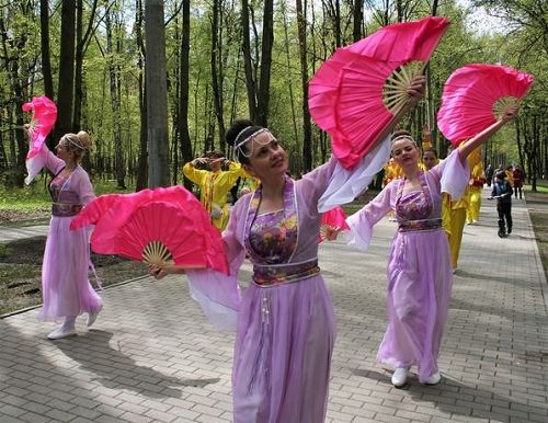 '图9~11:法轮功学员们载歌载舞的在公园内游行'