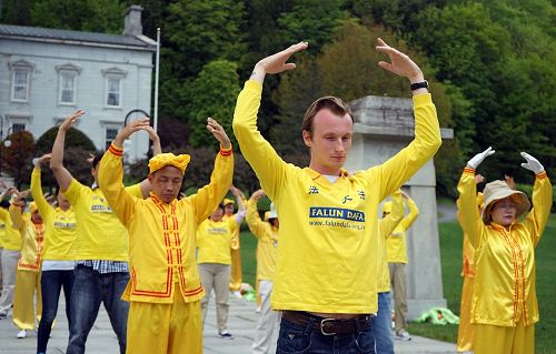'图1~2:二零一七年五月二十七日,部份来自美国和加拿大的部份法轮功学员在美国佛蒙特州政府前举办欢庆“世界法轮大法日”活动。图为法轮功学员们集会炼功,展现大法的美好。'