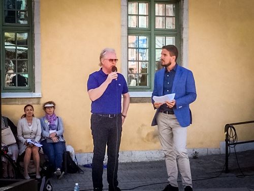 '图1:七月五日图比亚斯(右) 在维斯比中心广场讲真相活动的集会上与前来声援法轮功学员反迫害的温和党国会议员汉斯·罗森贝耶先生(左)在一起,图比亚斯在政治周活动期间,多次向人们介绍法轮功真相,引起了媒体的关注'