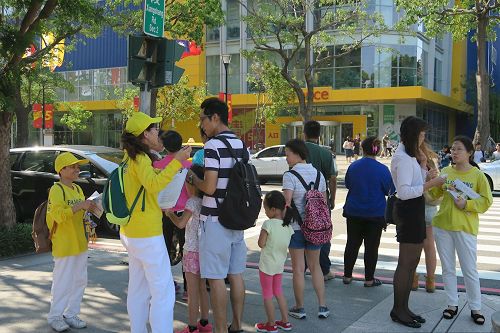 '图8:法轮功学员在集会场附近派发资料,向民众讲真相,征集联署声援诉江。'