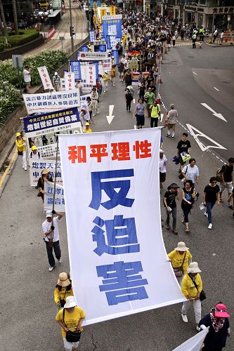 图5-7. 法轮功学员的游行队伍传达法轮大法好、和平理性反迫害以及善劝三<span style='max-width:0px!important;margin-left:-4px;color:#eee!important;'>:</span>退<span style='max-width:0px!important;margin-left:-4px;color:#eee!important;'>.</span>保平安的真相与讯息。