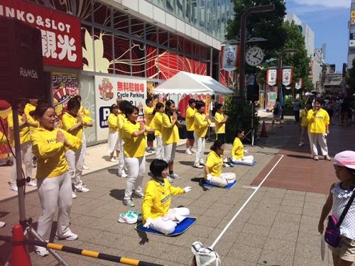 '图8~9:八月六日(星期天)下午,法轮功学员们在四日市市近铁车站附近的“第五十四届大四日市庆祝活动”的广场上,表演了法轮功的五套功法。'