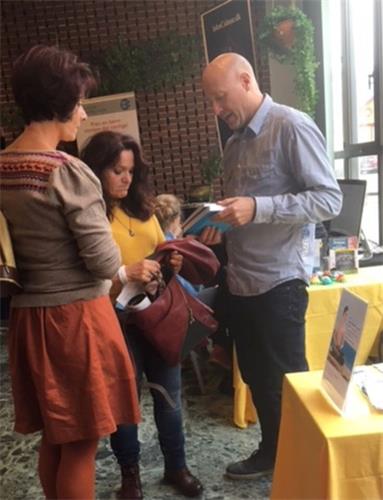 '法轮功学员(右一)向民众介绍法轮功和书籍'