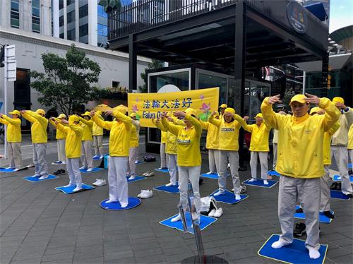'图1：法轮功学员在奥克兰天空城炼功、讲真相。'