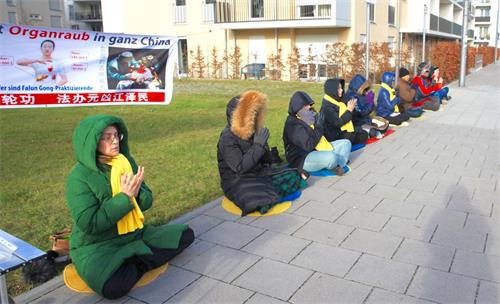 '图4:二零一八年十二月八日,来自德国和奥地利的法轮功学员在的德国慕尼黑中领馆对面举办活动,制止中共迫害法轮功。'