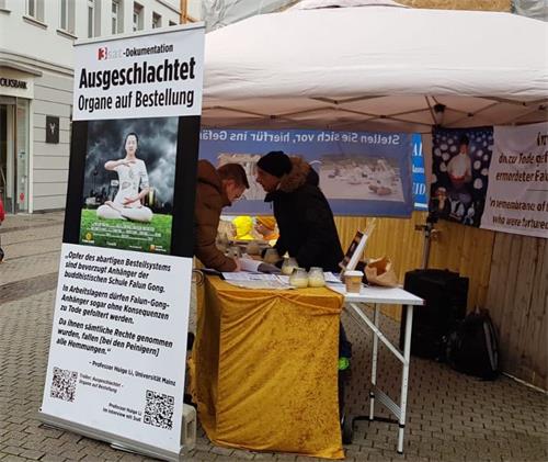 '图5:法轮功学员在海德堡主街与剧院大道交汇处举办活动,民众签名声援。'