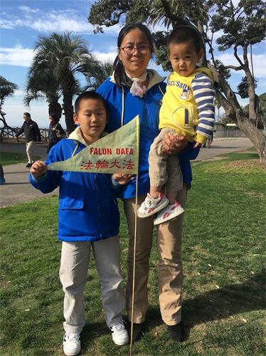 '图3:许女士带着二个儿子感谢法轮功师父,祝师父新年快乐。'