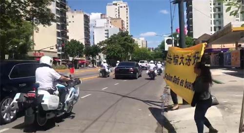 '十二月二日，习*近*平离开时，法轮功学员在前往机场的路上，向其车队展示真相横幅。'