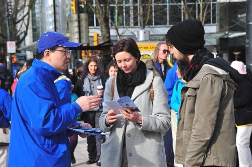 图2~3:很多行人驻足了解法轮大法真相。