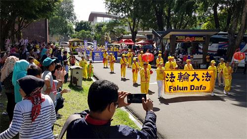 '图5：游客开心地欢迎法轮功的游行'