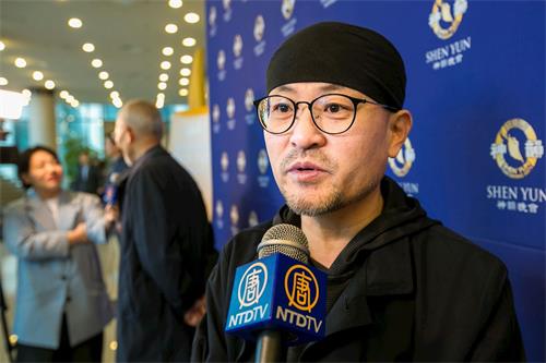 '图7:木偶剧团董事长安成均四月四日下午观赏神韵在韩国蔚山文化会馆的演出。'