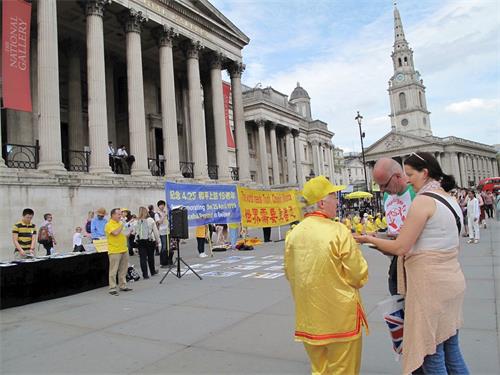 '图17~27:纪念“万名法轮功学员北京和平上访十九周年”,法轮功学员在特拉法加广场举行集会、功法展示、讲真相、征签反迫害等系列活动,民众踊跃了解真相,在要求制止中共活摘法轮功学员器官的征签表上签名'