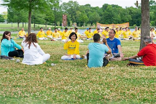 '图6:北德州大学学生Ian(身着天蓝色T恤者)与其他人一起在学法轮功的第五套功法。'