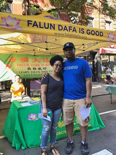 图3:这对情侣听完学员介绍法轮功后,高兴地在法轮大法展位前拍照留念。