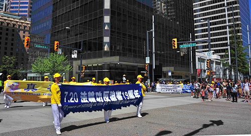 图12~13:法轮功学员的游行途经温哥华市中心繁华路段,很多游客兴奋地在路边纷纷拍摄法轮功学员的游行队伍。