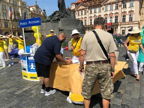 '图1:人们在请愿书上签字,支持法轮功反迫害'