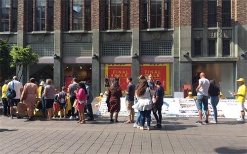 '图2:法轮功学员在海牙最繁华的市中心传播真相'