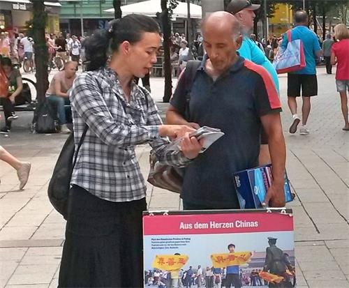 '图2~6:尽管天气炎热,许多路人还是停下脚步了解真相。'