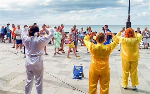 '图1:二零一八年九月八日,克里米亚法轮功学员来到苏达克市的海边,向民众介绍法轮功。'