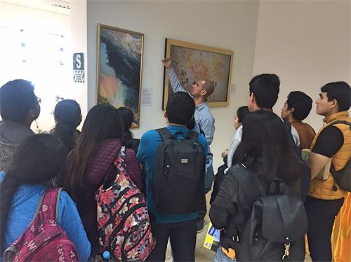 '图2~3:工作人员为学生讲解每一幅作品。'