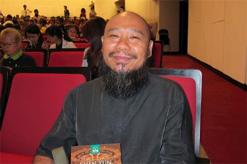 '图9:怀墨斋负责人、中华茶艺联合促进会台南会理事长洪国华,九月二十七日晚于台南市立文化中心欣赏神韵交响乐团演出。'